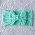 Detailed close-up of mint green cable knit baby headband with a large soft bow decoration - Mint Green