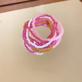 Close-up of bohemian beaded bracelet set on a gold mirror with elegant reflections - Pink (6-Piece Set)