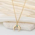 Close-up of golden crescent moon pendant with blue stone inlay and fine chain detail - Turquoise Inverted Moon