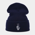 Détail de la broderie de main de squelette blanche sur un bonnet en tricot bleu marine - Bleu marine