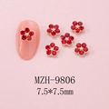 Macro shot of 7.5mm red rhinestone flower nail charms with gold bead center on tips - Red Rhinestone Flower (9806) / 1 Piece