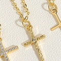 Macro della collana con pendente a croce in oro con zirconi e dettagli incisi - Croce con Singola Zirconia