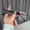 Detail shot of vintage round black sunglasses with metallic frame held by a hand - Black Frame Clear Lens