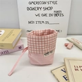 Detailed close-up of pink checkered canvas drawstring stationery bag with fabric brand label - Blush Pink Plaid