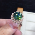 Dettaglio macro dell'anello con pietra verde tonda, halo floreale e fascia oro rosa - Aperto Regolabile / Colore Oro Rosa [3 Carati]
