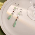 Detailed view of vintage jade-style beaded earrings with green teardrop tassels on ceramic - E2616-2/Green Drop Tassel