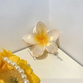 Pinza para el pelo con flor de frangipani blanco perlado y centro amarillo sobre libro - 8cm / Amarillo