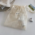 Close-up of cream mesh lace drawstring bag with white daisy flower embroidery details - Grid Style / Medium (21x26cm)