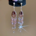 Detalle de pendientes boho con borlas largas, cristal de gota rojo y cuentas de color púrpura - Poste de pendiente de plata - Rosa