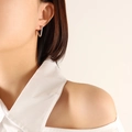 Minimalist silver triangle hoop earrings for women shown worn on ear in a studio shot - Wide Triangle / Silver