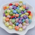 Colorful shell shaped ceramic beads for jewelry making displayed in a white petal bowl - 12mm / Multi-color