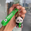 Close-up of cute 3D panda keychain with green wrist strap and bamboo holding detail - Bamboo Strap - Hugging Bamboo