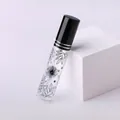 Dettaglio del flacone di profumo da 10ml in vetro con motivi floreali neri e tappo spray - Stile Linea di Taglio / Nero