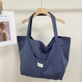 Detail of navy blue striped canvas tote bag showing the front pocket and logo label - Gray Blue