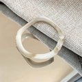 Dettaglio anello in resina marmorizzata irregolare con motivi beige e marroni sfumati - Bianco Sporco