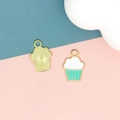Detailed view of cupcake-shaped gold pendants with white and mint green enamel finish - 2 Green Dessert