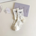 Detail of white crew socks featuring black polka dots and delicate bow embroidery - One Size / White