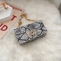 Chic snakeskin print crossbody bag with gold ring buckle on soft white plush background - Light Gray