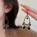 Detail view of ethnic bronze drop earrings with black beads and bohemian tassel design - 44# Ear Hook - Gold - Grey