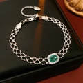 Detail van een vintage zilveren armband met ovale groene smaragd en zirkonia-halo-zetting - Armband - Zilver / Zilver