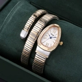 Macro view of gold and silver snake wrap watch with diamond-set bezel on velvet - Two-tone Gold White