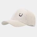 Detailansicht der süßen Smile-Stickerei auf einer beigefarbenen Cord-Baseballkappe - Verstellbar / Weiß