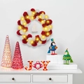 Kerstkrans met LED JOY bord en rood-witte versieringen op een wit dressoir - Rood Met LED Verlichting