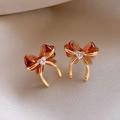 Macro shot of retro bow earrings with amber resin and heart-shaped crystal center - Bow Heart Zircon - Brown (Silver Earring Post)
