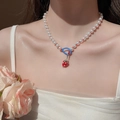 Détail du collier de perles avec perles bleues et pendentif fraise rouge sur le cou - 33# Collier pendentif fraise perles de rocaille bleues perle blanche