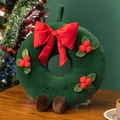 Detail of Christmas wreath plush with red bow and berries on a wooden table - Wreath with Legs