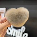 Close-up of light brown heart-shaped faux fur hair clip with soft plush texture - Brown
