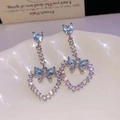 Elegant silver bow earrings with blue heart pendant and crystals on a white ceramic plate - Silver Pin Blue Heart