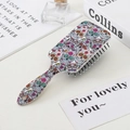 Sugar skull hair brush on a styled vanity table with books and perfume bottles - Many Skulls