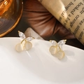Primer plano de pendientes de cereza con piedras ojo de gato y detalles de hojas de cristal - Dorado y Ojo de Gato Blanco