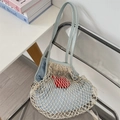 Detail of woven mesh tote bag with blue liner and red heart charm on transparent chair - Blue