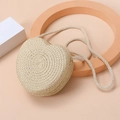 Macro detail of natural straw heart-shaped bag with intricate spiral weaving texture - Beige