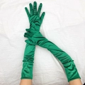 Dettaglio di guanti lunghi in raso verde smeraldo con trama setosa per festa vintage - Taglia unica / Verde Scuro