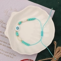 Detail of handmade evil eye beaded bracelet with teal beads and adjustable woven cord - Style 19-Turquoise Evil Eye Bracelet