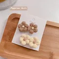 Details von vier matten 4cm Blumen-Haarspangen in Braun und Creme auf einer Displaykarte - Blumen-Set