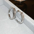 Primer plano de aretes de aro plateados con circonitas brillantes en un estuche joyero - Estilo de Círculo con Hebilla Plateada
