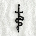 Détail d'un pendentif vintage en alliage noir représentant un serpent enroulé sur une épée - Noir