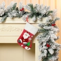 Detalle de calcetines de Navidad de felpa con motivos de Papá Noel colgados en una chimenea - Papá Noel