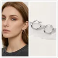 Créoles torsadées en argent au design vintage texturé sur un mannequin femme - Boucle d'Oreille Torsadée Argentée