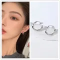 Silver twisted hoop earrings with a vintage textured design on a female model - Silver Twisted Ear Buckle