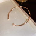 Elegante bracciale rigido aperto intrecciato in oro rosa con sfere metalliche lisce - Oro rosa