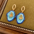 Detailed close-up of vintage flower earrings with blue enamel and golden floral center - Short Style / Gold-Blue