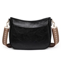 Detalle de bolso negro con correa tejida geométrica naranja y herrajes dorados - Negro