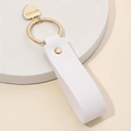 White leather heart keychain with gold ring and BEIS LOVE engraving on a round base - White