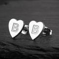 Macro shot of heart-shaped stainless steel earrings featuring an engraved letter B detail - B Steel Color