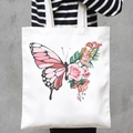 White canvas tote bag featuring floral butterfly print held by a model in casual attire - Rose Butterfly (STD707-B)